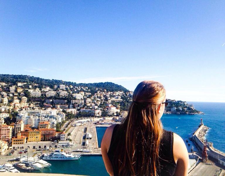 Study abroad student looks out over city and coast in Nice, France.